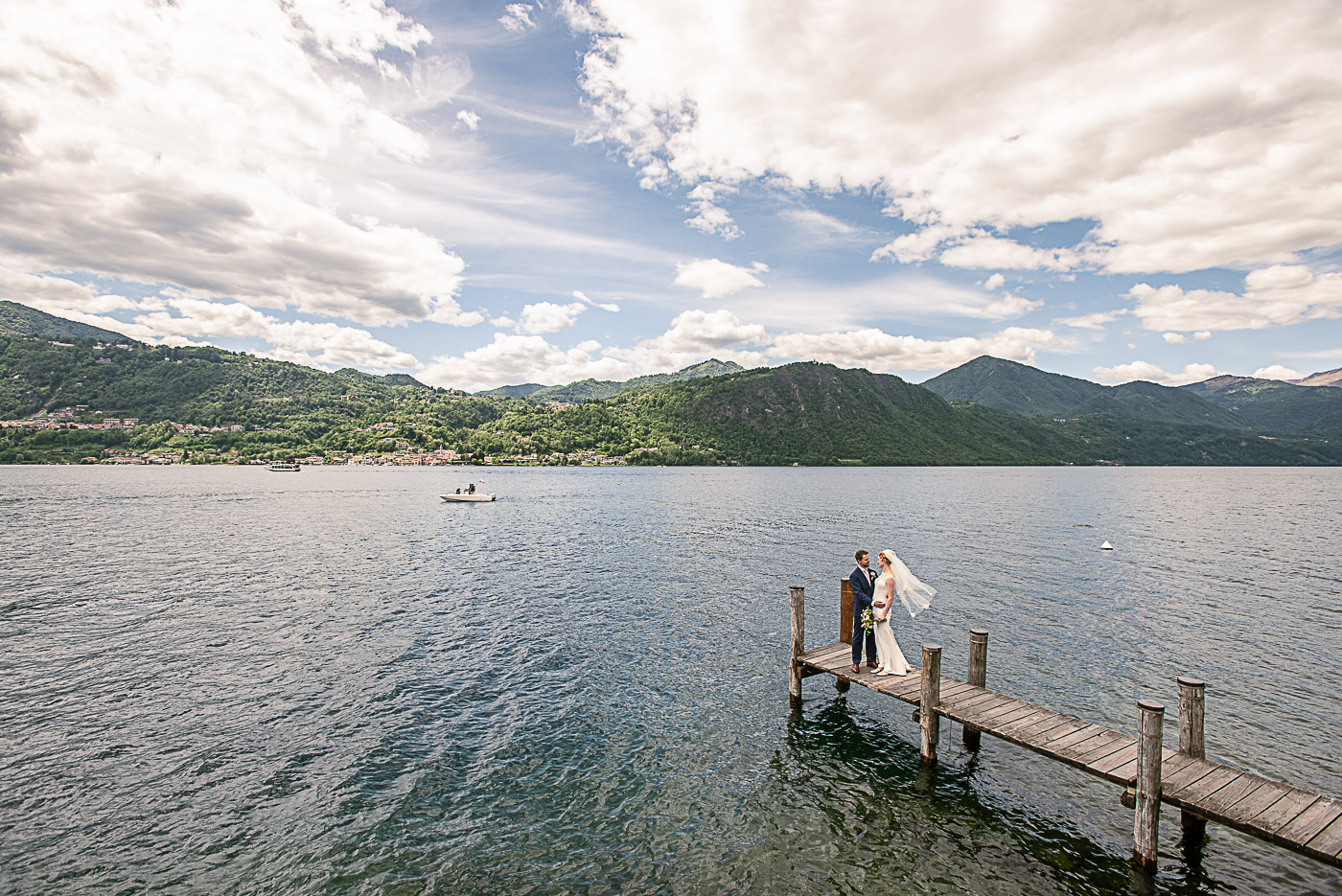 Bride and groom on a jetty by the lake Orta