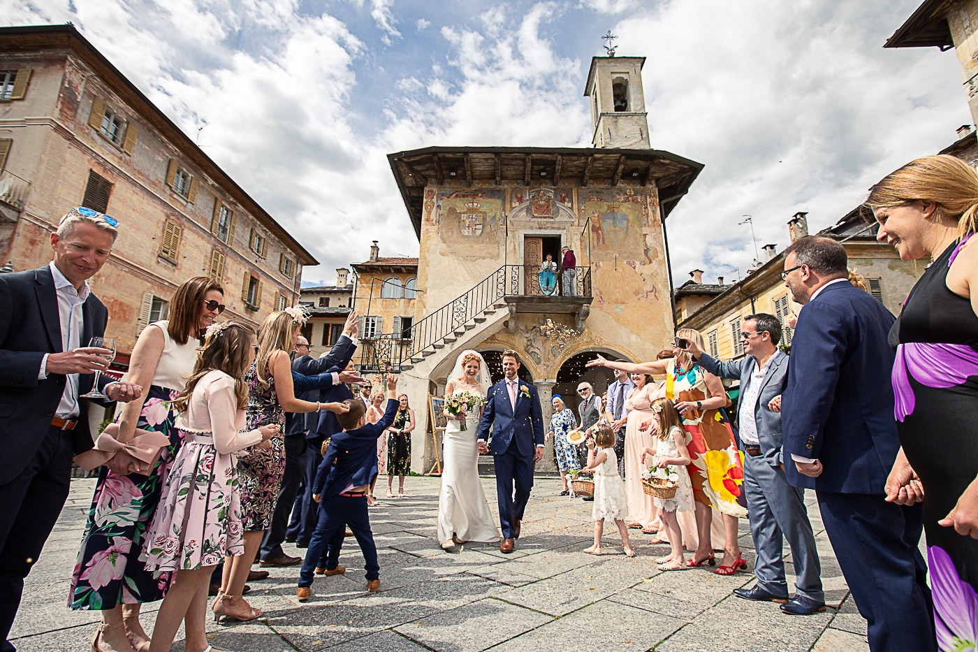 bride and groom in piazza at Orta with guests throwing confetti