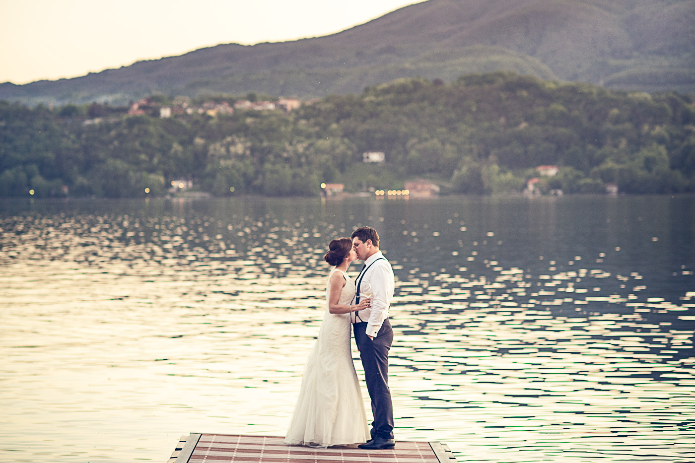 Bride's romantic kiss to the groom by the lake Orta