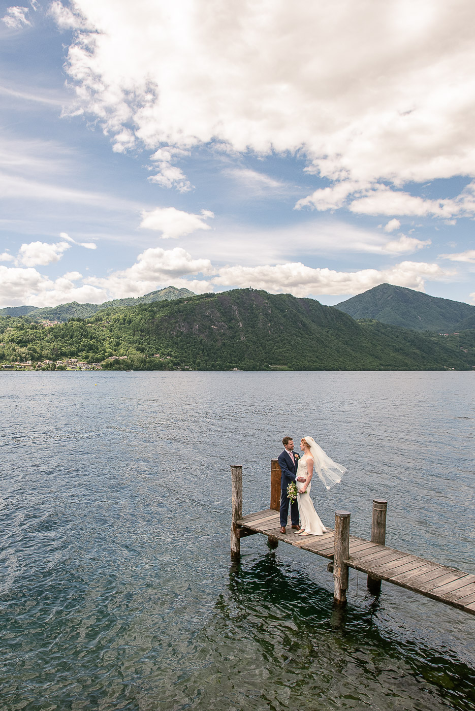 bride and groom on a jetty at lake orta