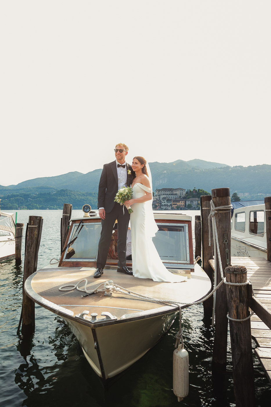 Bride and groom are taking a boat on lake orta Italy