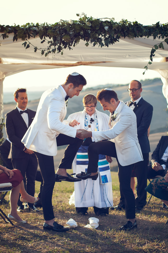 same sex Jewish wedding in Italy, both grooms are breaking the glass